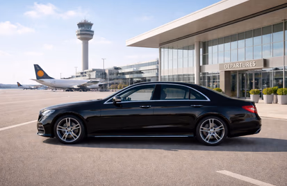 Black executive saloon outside an airport departures terminal