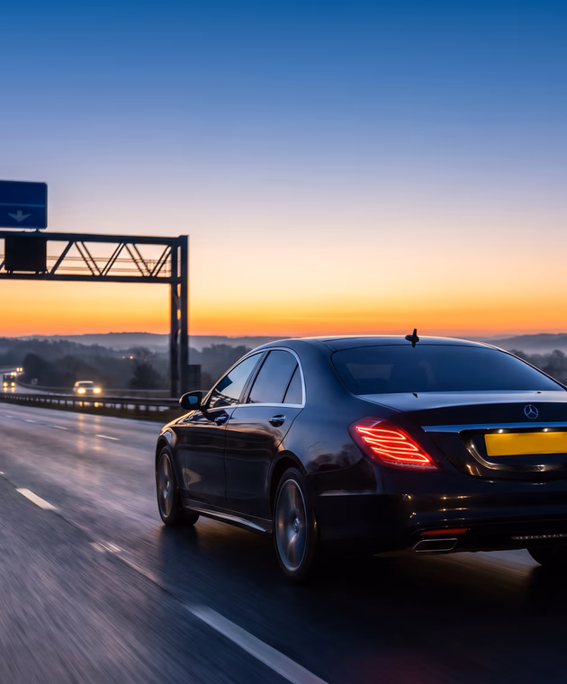 Executive chauffeur car on a motorway at dawn, representing a Dorset to Stansted Airport private transfer